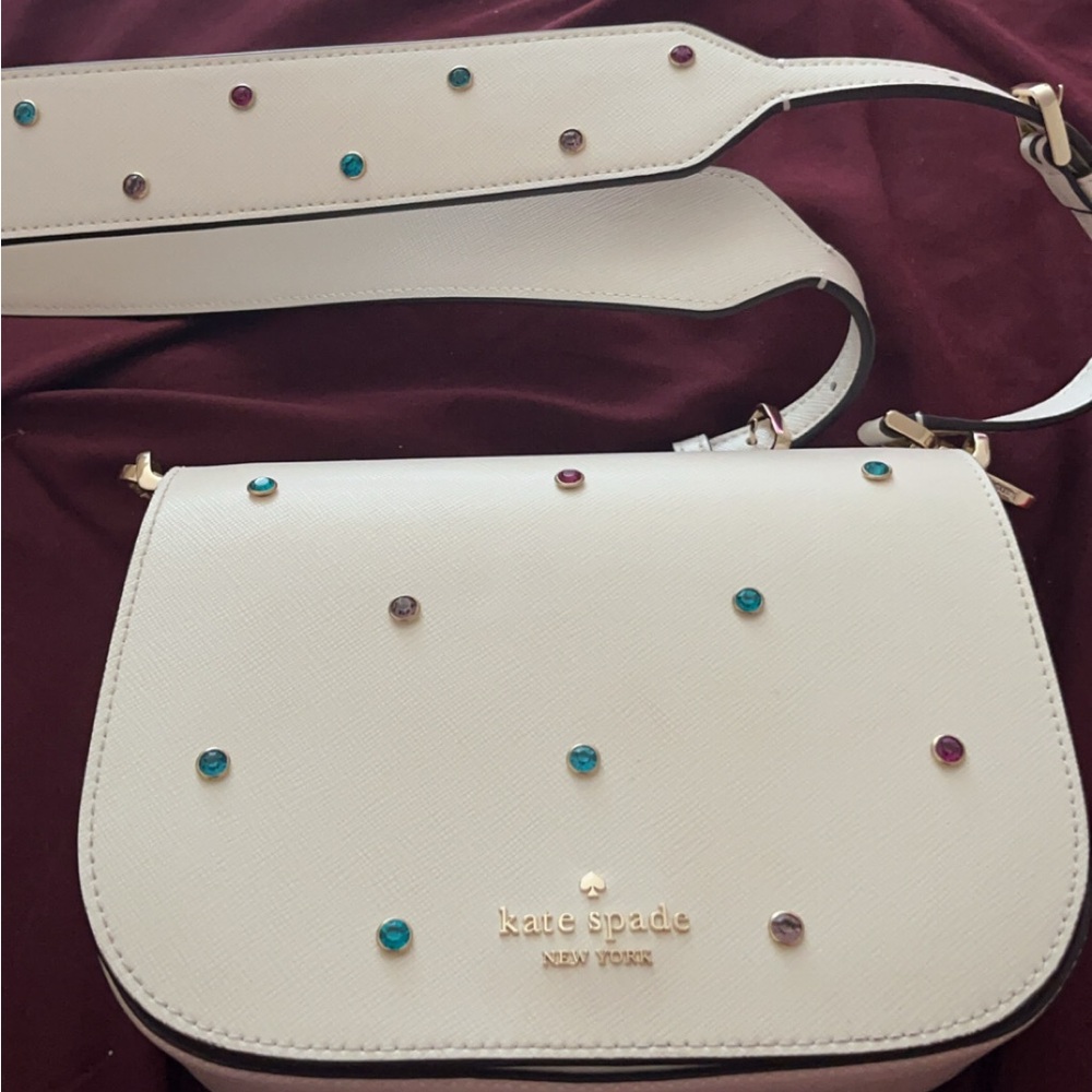 Kate Spade cream colored crossbody bag with pink, turquoise, and purple studs